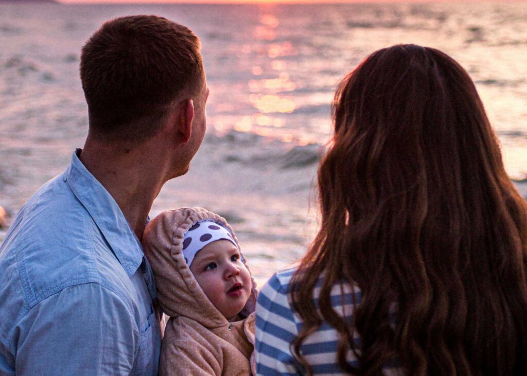Comment gérer l'impact de bébé sur la vie de couple ? 5 Couple avec leur bébé a la plage
