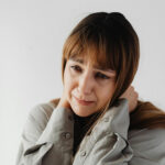 Portrait d'une femme en larmes exprimant une vulnérabilité émotionnelle sur fond blanc.